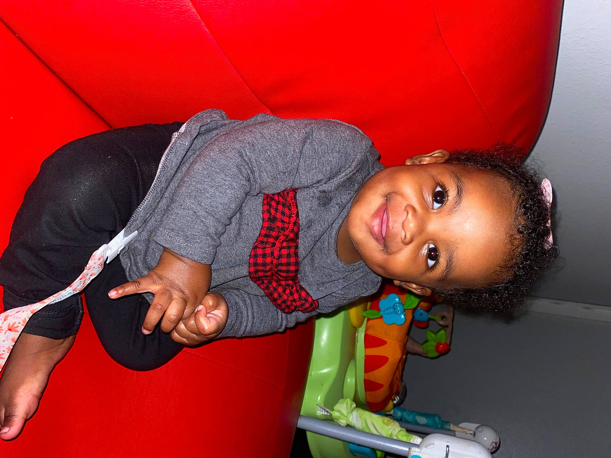 Jacelynn is registered to the contest to win money with this photo: arm, automotive_tire, child, elbow, facial_expression, flash_photography, fun, hairstyle, happy, human_body, human_leg, joint, joy, leisure, mouth, person, red, sitting, smile, t_shirt