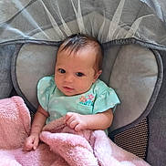 Harper joined the competition — help win amazing prizes! baby, infant, blanket, pink_blanket, baby_seat, cushion, netting, green_outfit, flowers, hand, face, head, curious, indoors, soft_texture, cozy, child, newborn, portrait, resting
