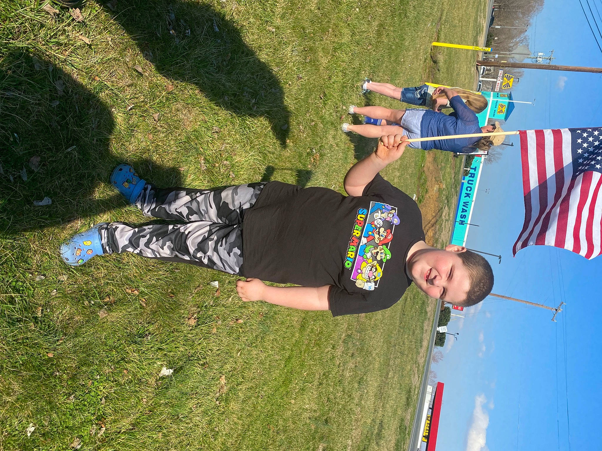 Tyson joined the competition — help win amazing prizes! adventure, flag, flag_of_the_united_states, fun, grass, grassland, joy, leisure, people_in_nature, person, pole, recreation, shadow, shorts, sky, t_shirt, tree, walking_shoe