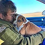 Boudreau joined the competition — help win amazing prizes! animal, brown_and_white, car, close_up, compassion, cuddle, dog, face, field, green_jacket, hugging, love, nature, outdoor, person, pet, puppy, seat, sky, window