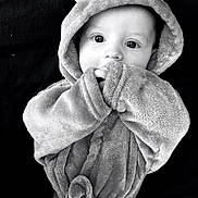Cain is registered to the contest to win money with this photo: adorable, apparel, baby, black_and_white, child, costume, cozy, cute, eyes, face, hand, hooded_robe, indoors, infant, person, plush, portrait, sleeves, soft_texture, wearing