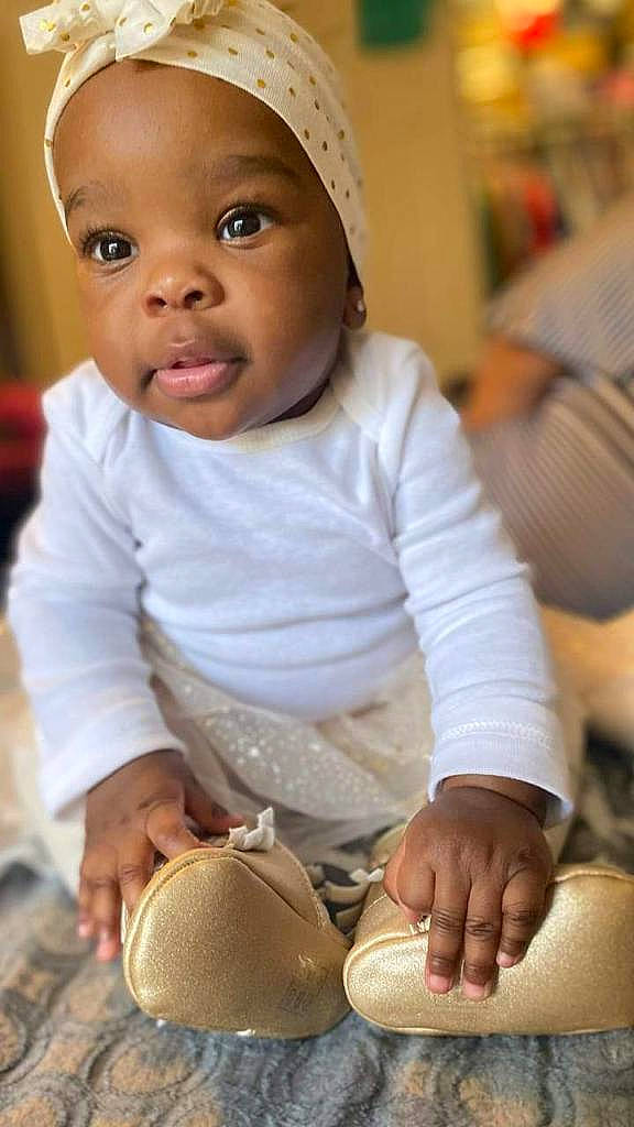 Kamaria joined the competition — help win amazing prizes! baby, baby_toddler_clothing, cheek, comfort, facial_expression, finger, floor, hand, happy, headgear, human, nose, organ, person, photograph, product, skin, sleeve, smile, toddler