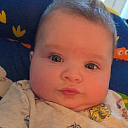 Isaac is registered to the contest to win money with this photo: baby, infant, face, child, cute, toddler, cheeks, hair, clothing, cushion, blue, yellow, pattern, indoor, portrait, expression, young, closeup, person, soft