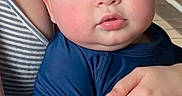 Isaac is registered to the contest to win money with this photo: baby, child, blue_eyes, long_sleeve_shirt, curly_hair, adult_hand, striped_clothing, close_up, indoor, person, portrait, skin, expression, holding, face, young_child, cute, curious, natural_light, human