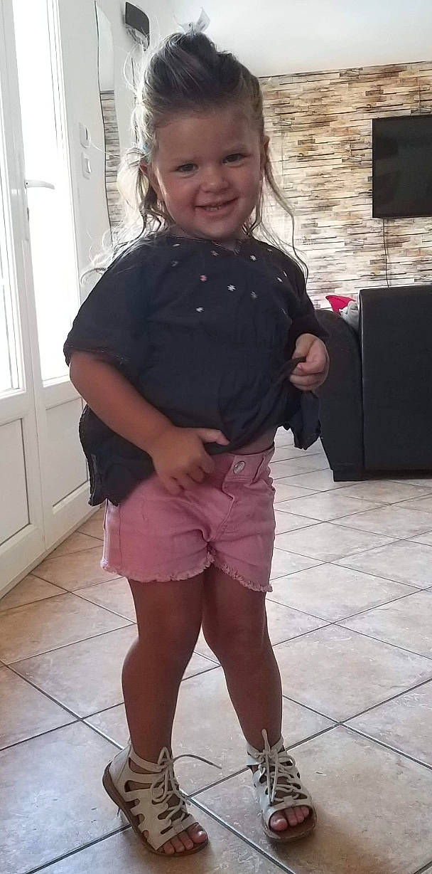 Clara participe au concours pour gagner de l'argent avec cette photo : child, head, joint, joy, leg, person, pink, shoe, shorts, shoulder, smile, t_shirt, thigh, toddler