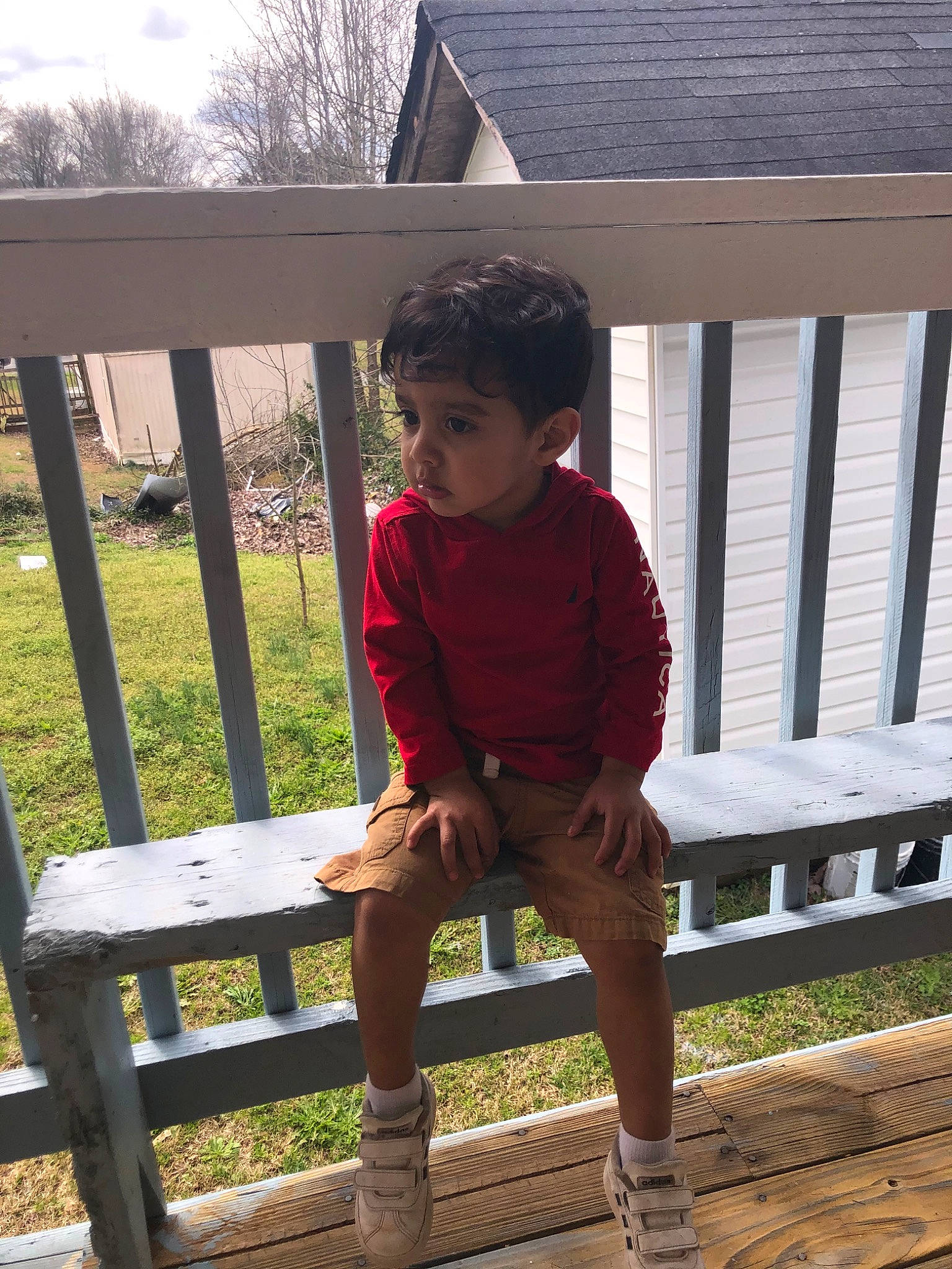 Damian is registered to the contest to win money with this photo: child, deck, furniture, outdoor_furniture, outerwear, person, sitting, standing, table, toddler