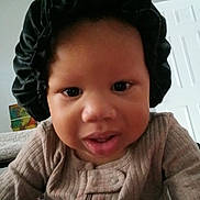 Mckayla joined the competition — help win amazing prizes! baby, child, face, bonnet, clothing, indoor, portrait, curious, close_up, infant, person, young_child, home, furniture, door, wall_art, sleeves, looking, expression, cozy