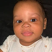 Myles joined the competition — help win amazing prizes! adorable, baby, background, bear_print, child, closeup, clothing, curly_hair, cute, expression, face, hands, indoors, infant, light_skin, looking_at_camera, person, portrait, smile, young_child