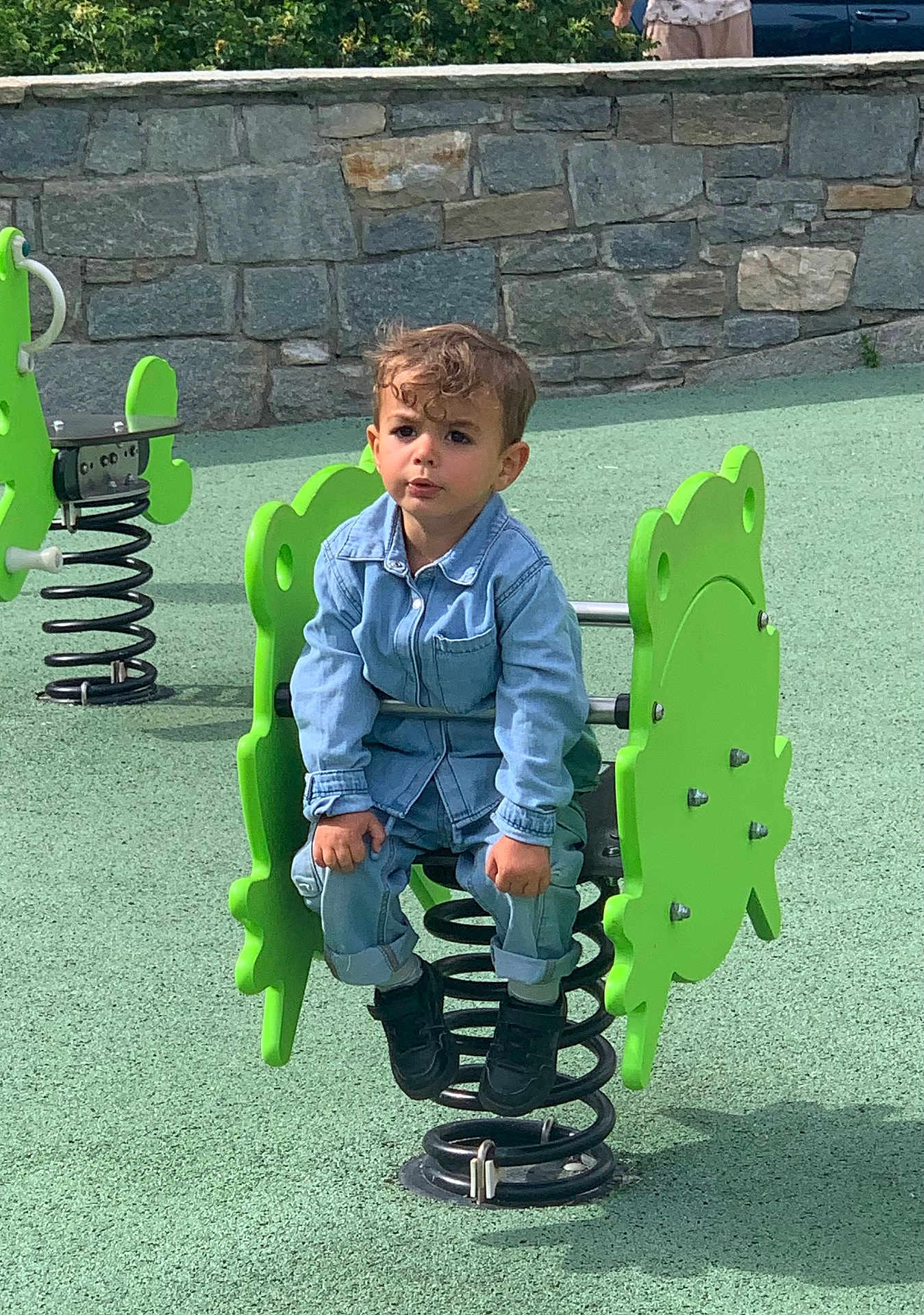 Sao a rejoint le concours — aidez-le/la à gagner de superbes lots ! child, toddler, playground, spring_rocker, green, denim, curly_hair, outdoor, play, fun, casual_clothing, stone_wall, park, toy, spring, black_shoes, young_child, daylight, recreation, leisure
