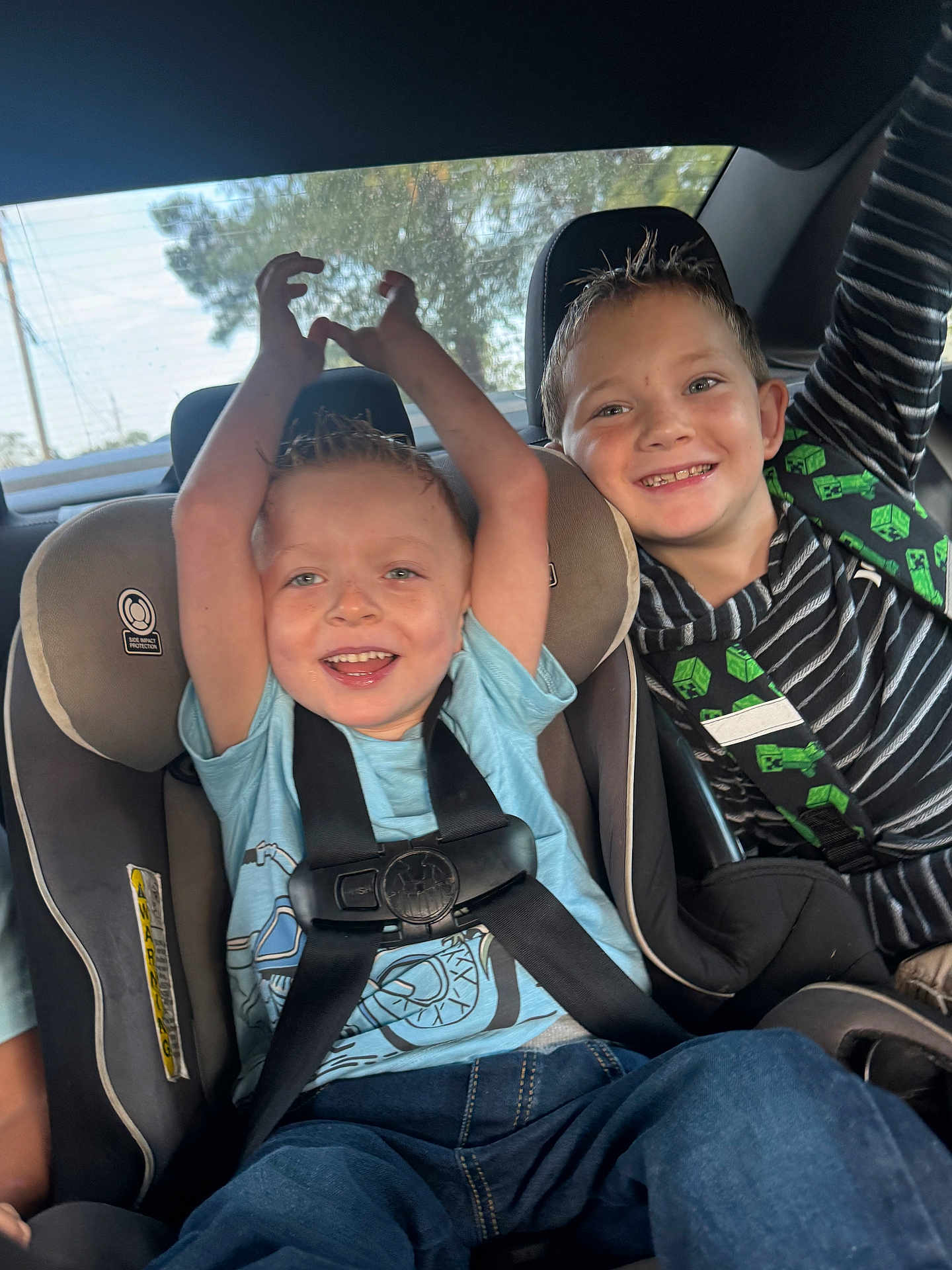 Kyson is registered to the contest to win money with this photo: child, kids, car_seat, car_interior, seatbelt, smiling, happy, boy, blue_shirt, striped_shirt, jeans, window, sunlight, hair, seat, playful, safety, transportation, casual_clothing, portrait
