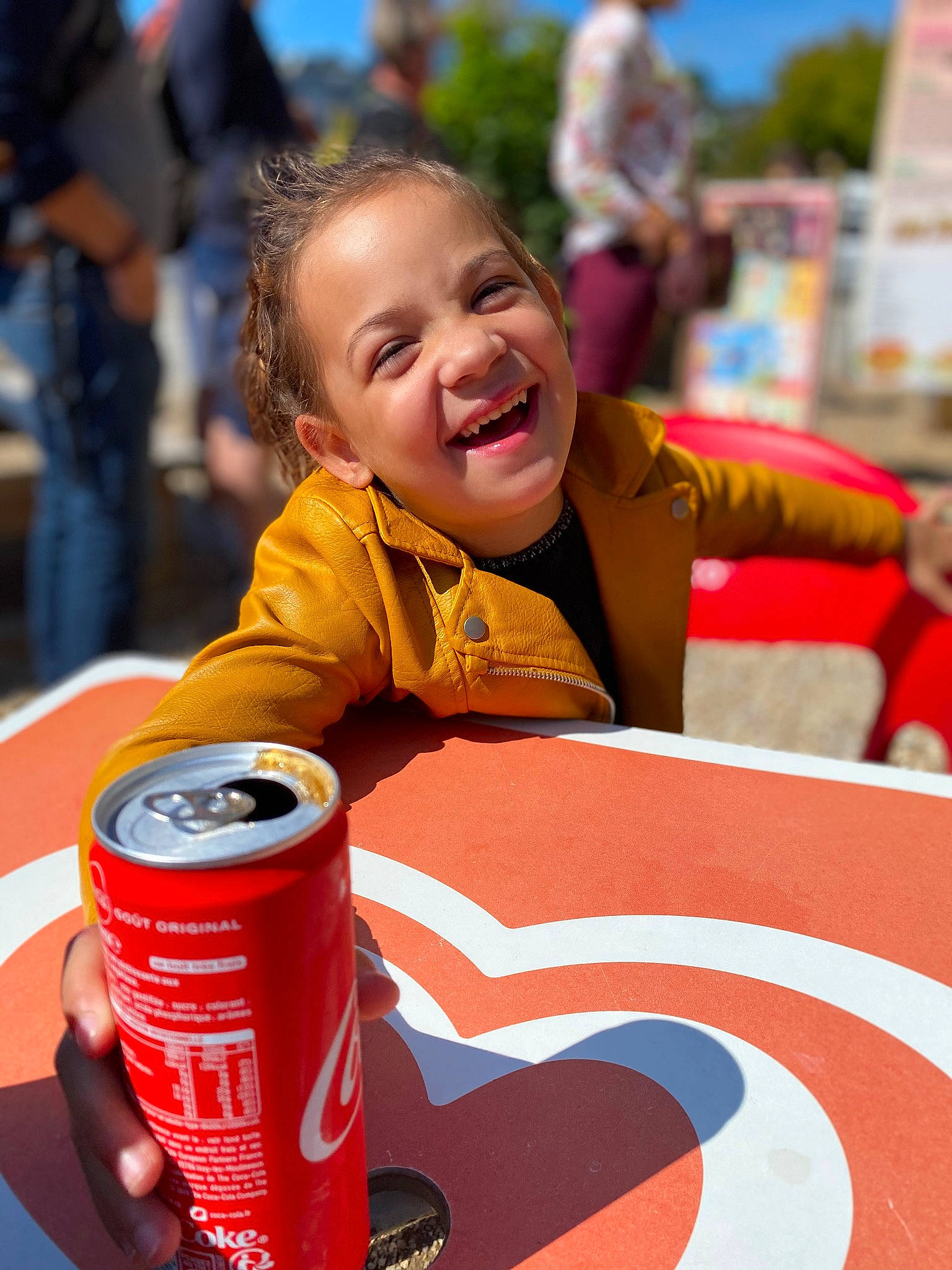 Mia participe au concours pour gagner de l'argent avec cette photo : aluminum_can, beverage_can, carbonated_soft_drinks, child, cola, drink, drinkware, event, fun, happy, joy, leisure, non_alcoholic_beverage, person, product, recreation, red, smile, soft_drink, tin