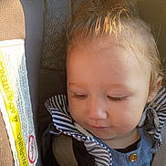 Alivia is registered to the contest to win money with this photo: child, car_seat, seatbelt, warning_label, striped_clothing, blue_clothing, young_child, blond_hair, closeup, indoors, sunlight, portrait, baby, safety, seat, head, face, young_person, casual_clothing, infant