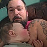 man, baby, sleeping, tattoo, beard, arm, couch, indoor, closeup, child, person, skin, head, resting, peaceful, holding, casual, portrait, intimate, family