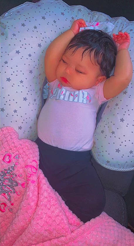 Khalani is registered to the contest to win money with this photo: arm, baby, baby_toddler_clothing, cheek, comfort, eye, finger, hand, head, human_body, leg, lip, mouth, neck, person, pink, purple, skin, stomach, textile