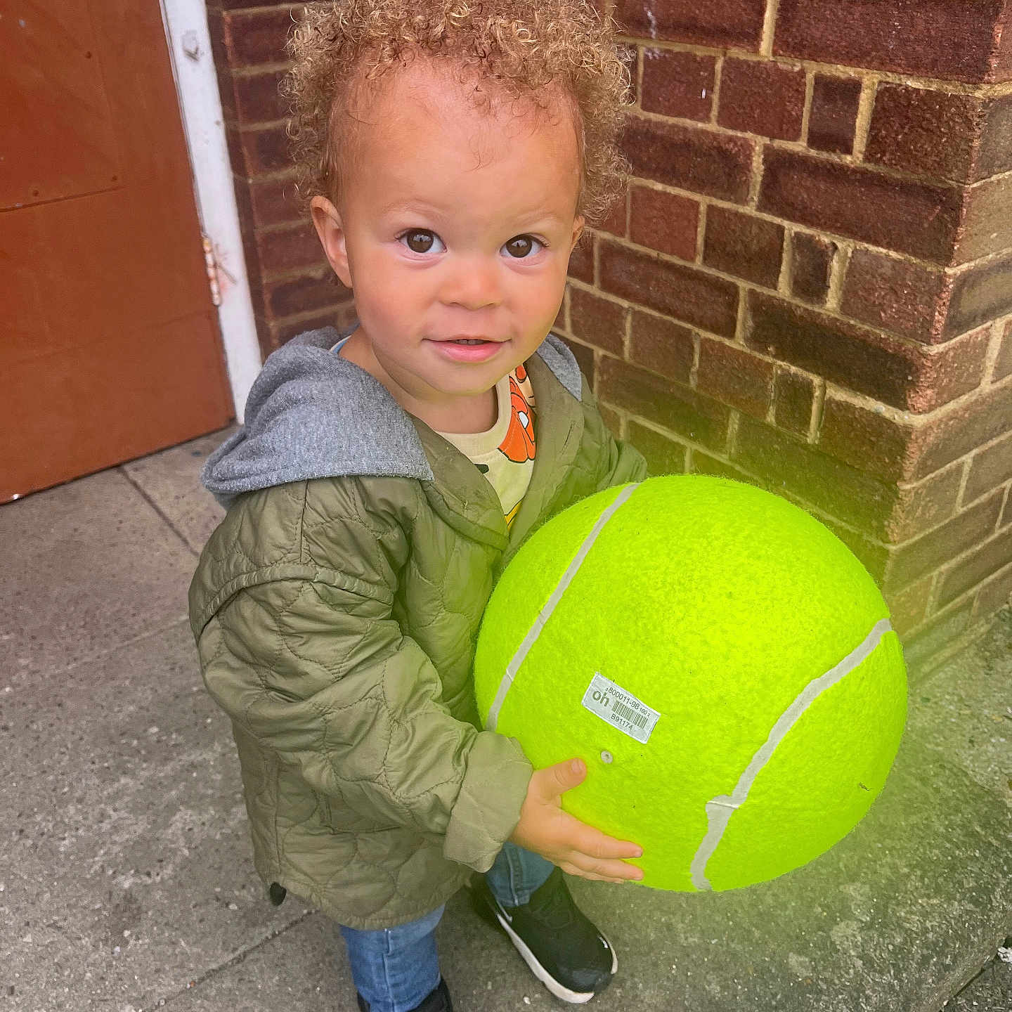 Cairo is registered to the contest to win money with this photo: ball, boy, child, clothing, coat, face, football, head, jacket, male, pants, person, photography, portrait, soccer, soccerball, sphere, sport, tennis, tennisball