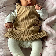 Yuna participe au concours pour gagner de l'argent avec cette photo : baby, corduroy, dress, white_tights, blanket, pink, infant, cute, lying_down, indoors, soft_texture, cozy, child, portrait, fist, clothing, person, young, warm, sleepwear