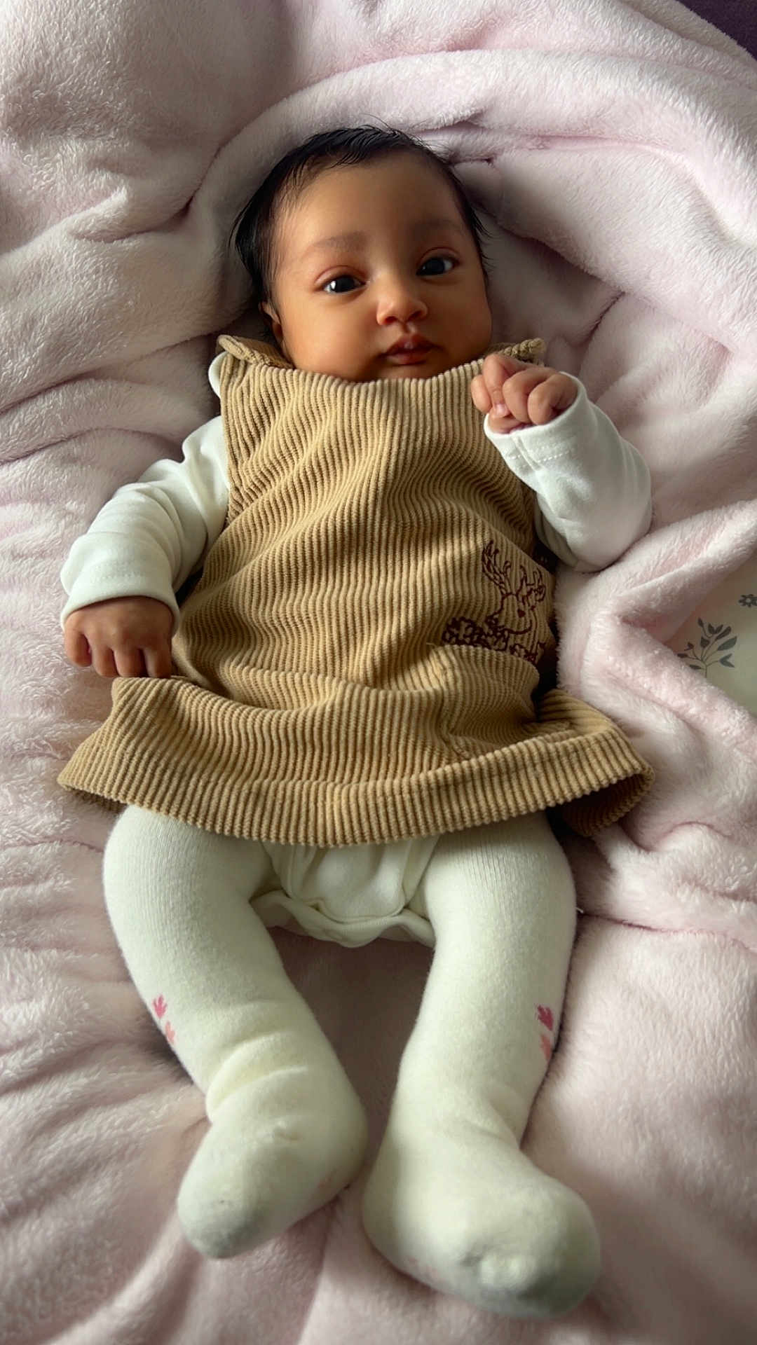 Yuna participe au concours pour gagner de l'argent avec cette photo : baby, corduroy, dress, white_tights, blanket, pink, infant, cute, lying_down, indoors, soft_texture, cozy, child, portrait, fist, clothing, person, young, warm, sleepwear