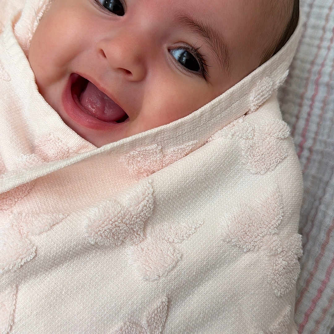 Bellamy joined the competition — help win amazing prizes! baby, smiling, wrapped, towel, butterfly_pattern, closeup, face, happy, infant, cute, soft_texture, blanket, child, portrait, skin, lying_down, young, expression, cozy, comfort