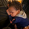 toddler, child, sleeping, curly_hair, hoodie, cushion, indoor, resting, peaceful, person, face, young_child, cozy, nap, clothing, casual, head, skin, comfort, relaxation