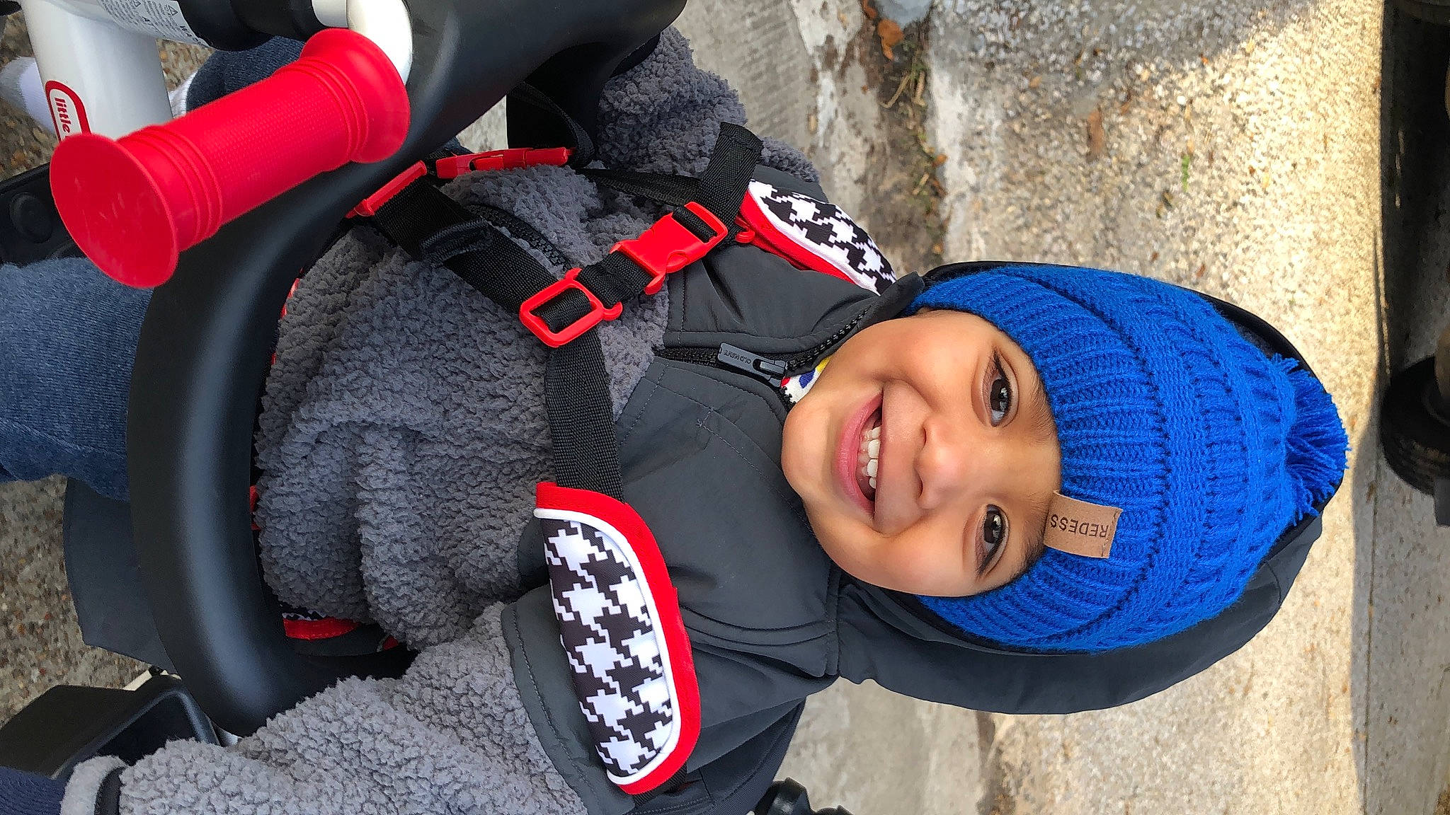 Keshav is registered to the contest to win money with this photo: auto_part, automotive_tire, automotive_wheel_system, baseball_cap, blue, cap, car_seat, carmine, child, electric_blue, face, fun, happy, hat, headgear, headwear, joy, person, smile, steering_wheel
