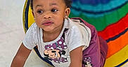 Aires is registered to the contest to win money with this photo: baby, backpack, child, clothing, crawling, curious, earrings, face, floor, giraffe, indoor, playroom, portrait, rainbow, shirt, smiling, tiles, toddler, toy, tunnel
