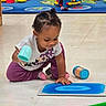 Aires joined the competition — help win amazing prizes! activity_mat, child, colorful, container, cup, early_learning, earrings, floor, focused, girl, hair_bun, indoor, playing, playroom, portrait, purple_pants, sitting, t_shirt, toddler, toys