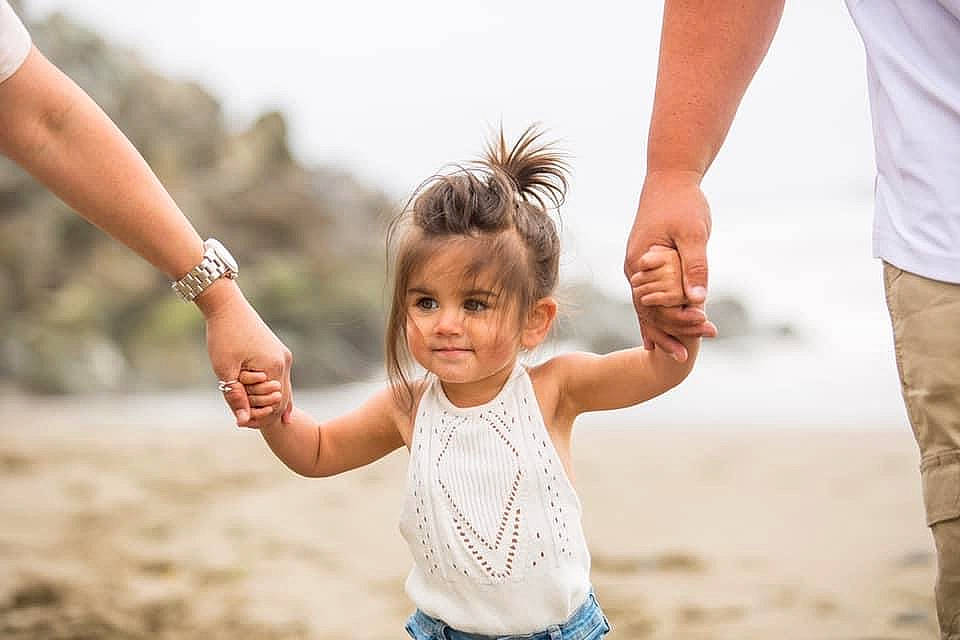 Aniyah is registered to the contest to win money with this photo: beach, finger, flash_photography, fun, gesture, hand, happy, landscape, leisure, natural_environment, people_in_nature, people_on_beach, person, sand, shore, sky, smile, summer, toddler, travel