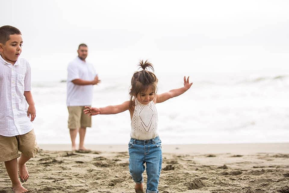 Aniyah is registered to the contest to win money with this photo: beach, blurred, clothing, coastal_and_oceanic_landforms, flash_photography, fun, gesture, happy, head, jeans, leg, people_in_nature, people_on_beach, person, playing_with_kids, sand, shirt, shorts, sky, t_shirt
