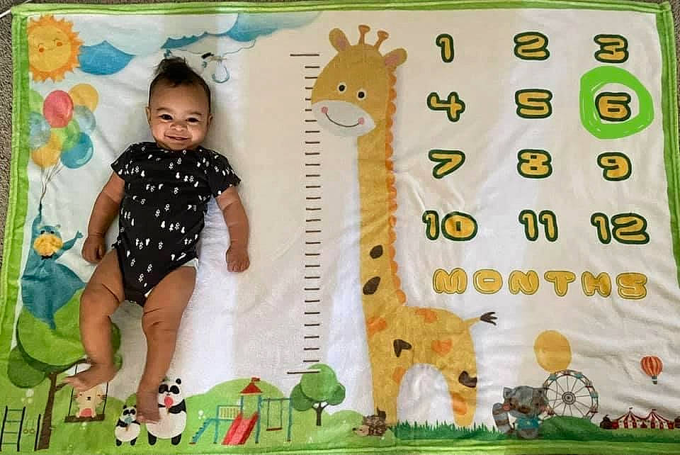 Lex is registered to the contest to win money with this photo: adaptation, baby_toddler_clothing, child, fawn, font, fun, giraffe, giraffidae, green, happy, insect, joy, linens, pattern, person, product, room, terrestrial_animal, textile, toddler