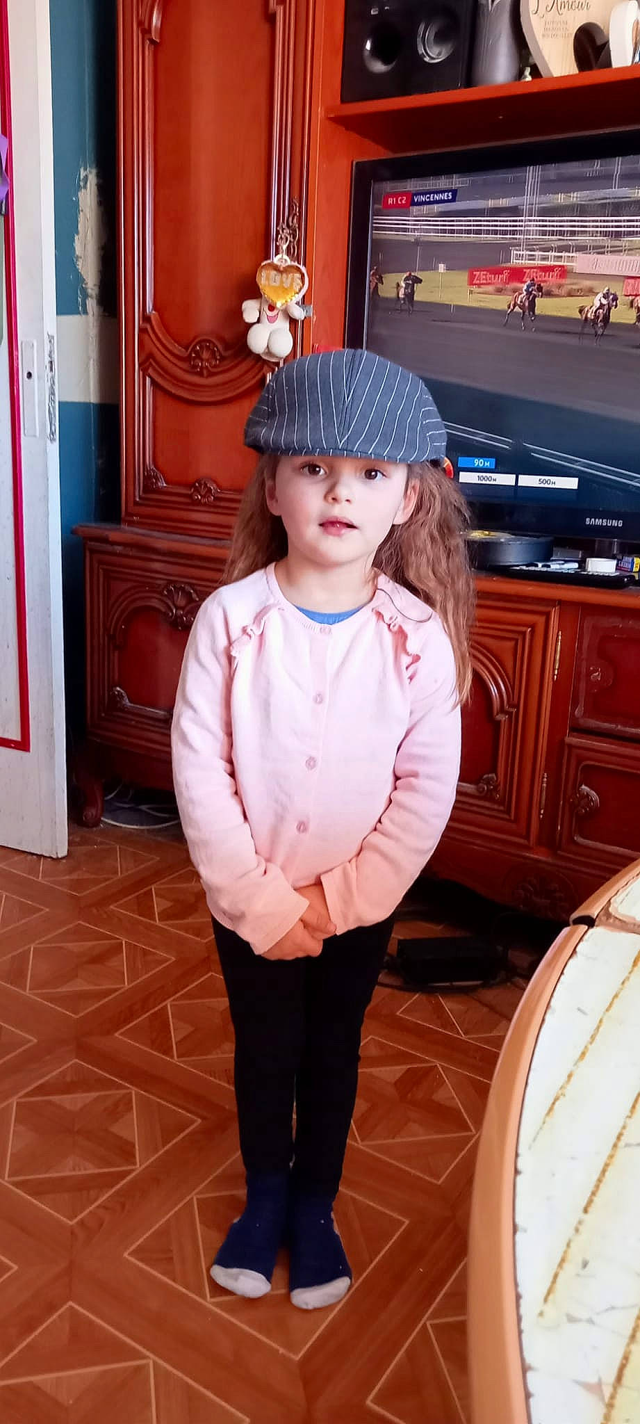 Amelie a rejoint le concours — aidez-le/la à gagner de superbes lots ! brown_hair, cabinetry, cap, cupboard, door, drawer, fashion_accessory, flooring, hairstyle, hardwood, hat, headwear, hime_cut, human_leg, long_hair, person, room, sleeve, standing, toddler