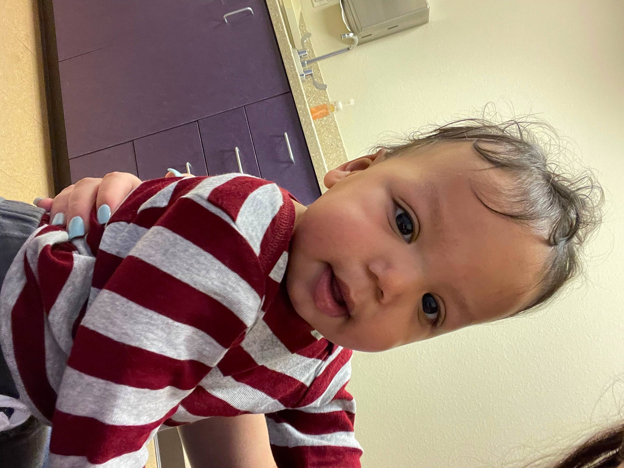 Damian is registered to the contest to win money with this photo: arm, baby, black_hair, cheek, comfort, eyelash, flooring, happy, human_body, iris, lip, mouth, neck, nose, person, shoulder, skin, sleeve, smile, toddler