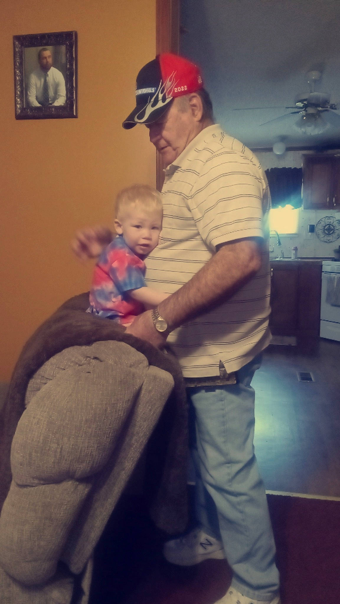 Drake is registered to the contest to win money with this photo: arm, baseball_cap, blurred, cap, comfort, event, fun, happy, hat, headwear, joint, lap, leg, muscle, person, picture_frame, room, shoulder, sitting, smile