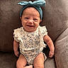 armchair, baby, bow, child, closeup, couch, eyes, face, floral_outfit, furniture, hands, happy, headband, indoor, infant, onesie, photography, portrait, sitting, smiling