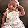 Alaynna joined the competition — help win amazing prizes! baby, blanket, child, couch, cozy, cute, face, fashion, floral_clothing, hand, headband, indoor, infant, photography, pink_shirt, portrait, romper, sitting, smiling, white_outfit