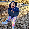Kailani joined the competition — help win amazing prizes! toddler, child, swing, playground, wood_chips, hoodie, smile, happy, outdoor, sunlight, leggings, colorful_clothing, person, play, fun, park, baby, joyful, winter_clothing, recreation