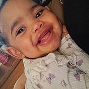 Kailani is registered to the contest to win money with this photo: baby, smiling, child, face, portrait, happy, person, clothing, hand, skin, indoors, holding, cute, infant, young, expression, closeup, warmth, love, family