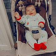 Matheïs a rejoint le concours — aidez-le/la à gagner de superbes lots ! baby, child, smiling, pajamas, baby_rocker, toys, indoor, floor, wooden_floor, happy, person, infant, clothing, cute, seat, playtime, home, comfort, red_socks, text_overlay