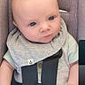 óðinn is registered to the contest to win money with this photo: baby, bib, blue_eyes, car_seat, child, clothing, cute, expression, gray_bib, hands, head, indoor, infant, person, portrait, safety, seat, seatbelt, straps, young_child