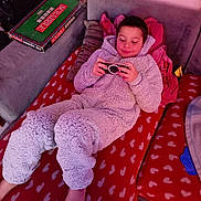 Aaron a rejoint le concours — aidez-le/la à gagner de superbes lots ! barefoot, blanket, board_game, boy, casual, child, comfortable, couch, game, handheld_device, heart_pattern, indoor, leisure, onesie, pillow, playing, red, relaxed, scrabble, smiling