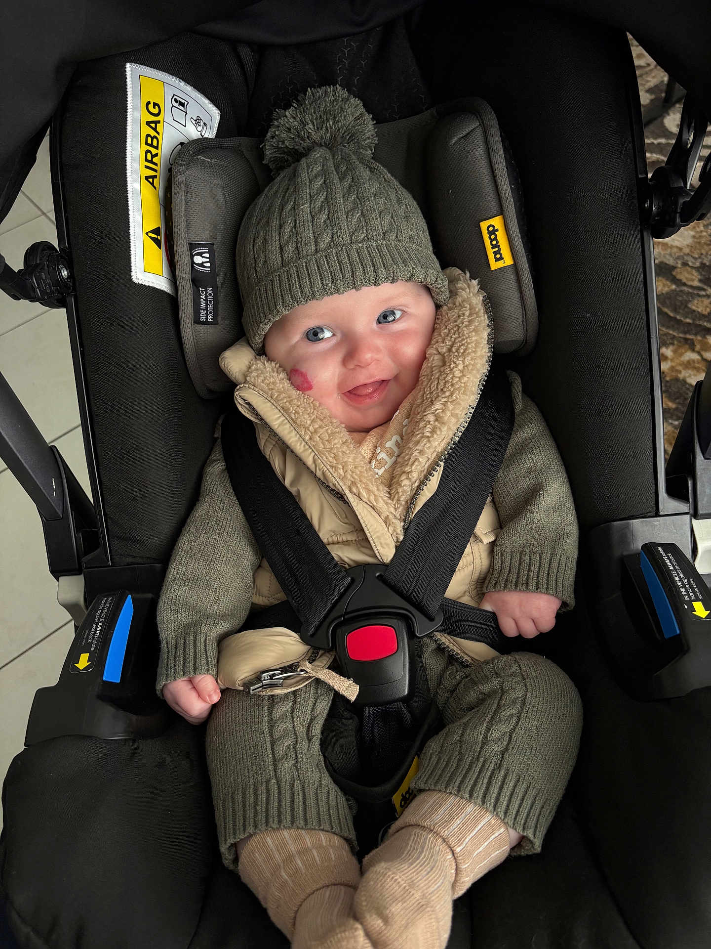 Arthur joined the competition — help win amazing prizes! baby, car_seat, knit_hat, pom_pom, smiling, child, winter_clothing, safety_harness, cute, happy, indoor, warm_clothes, face, person, seat, straps, jacket, socks, cozy, infant