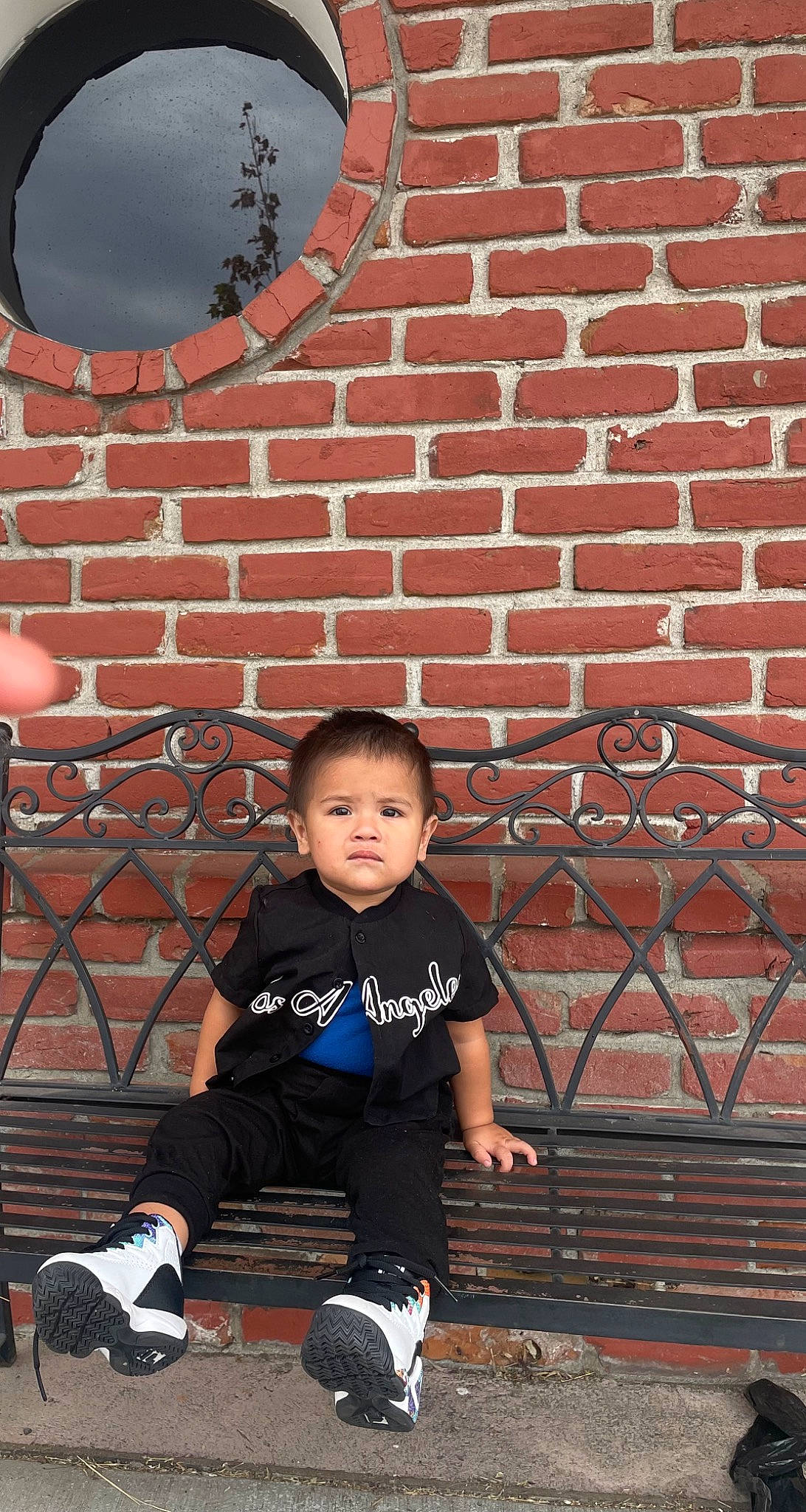 Elijah is registered to the contest to win money with this photo: brick, brickwork, flash_photography, flooring, fun, grass, human, leisure, line, person, photograph, red, shorts, snapshot, sneakers, sock, sorrow, standing, toddler, wall