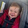baby, child, car_seat, red_jacket, smiling, happy, infant, seatbelt, straps, hair, face, person, indoors, closeup, cute, safety, child_safety, car_interior, clothing, seat