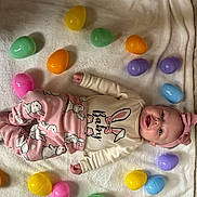 Ayla is registered to the contest to win money with this photo: baby, blanket, bunny, celebration, child, colorful, cute, easter_eggs, happy, headband, indoors, infant, lying_down, pajamas, pink, playful, smile, soft_texture, spring, toy