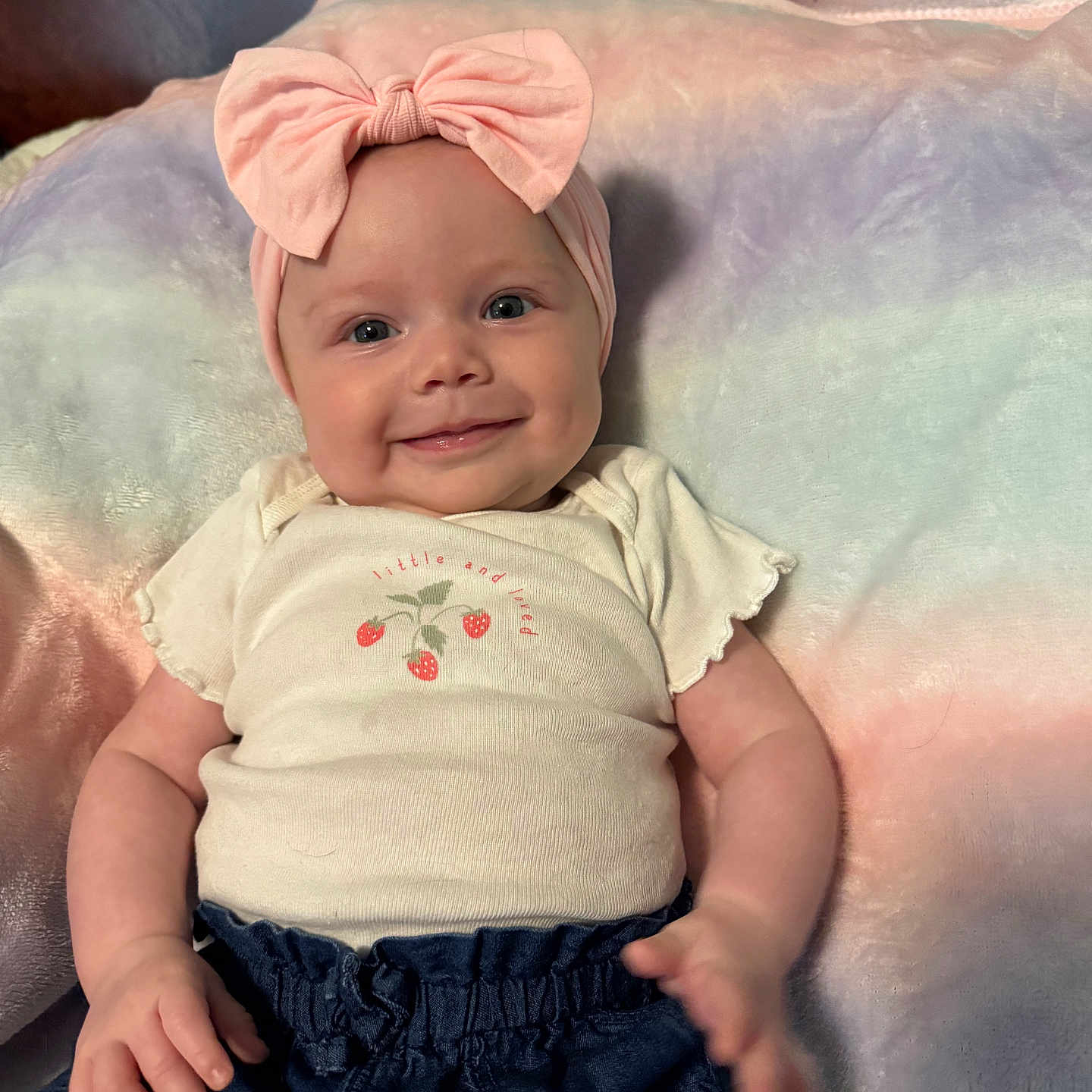 Ayla joined the competition — help win amazing prizes! baby, smiling, headband, pink_bow, infant, clothing, shorts, plush_blanket, pastel_colors, cute, happy, child, portrait, indoor, soft_texture, person, toddler, casual_wear, resting, closeup