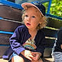 Nila a rejoint le concours — aidez-le/la à gagner de superbes lots ! bench, blue_eyes, cap, cardigan, casual_clothing, child, curly_hair, cute, daylight, expression, innocence, nature, outdoor, portrait, shorts, sitting, sunlight, toddler, wooden_steps, young_child