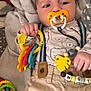 Kaylon a rejoint le concours — aidez-le/la à gagner de superbes lots ! baby, pacifier, toy, colorful, suspenders, pants, blanket, face, hand, clothing, infant, lying_down, indoor, plush, striped, pattern, cute, child, comfort, playtime