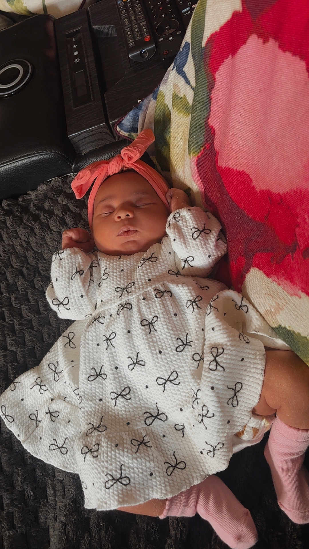 Imarah-Anne is registered to the contest to win money with this photo: baby, sleeping, infant, dress, headband, pink, white, pattern, bow, blanket, pillow, floral, remote_control, sofa, couch, child, indoors, cozy, peaceful, resting