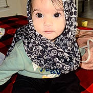 Jaapnoor Kaur is registered to the contest to win money with this photo: baby, child, scarf, face, eyes, sitting, blanket, indoor, clothing, cute, portrait, person, headwear, black_and_white, pattern, infant, young_child, looking_at_camera, warm_clothing, floor