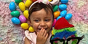 Eliahna joined the competition — help win amazing prizes! child, toddler, smiling, bunny_ears, pink_dress, stuffed_toy, glasses, red_hat, easter_eggs, colorful, fluffy_rug, playful, happy, indoors, cute, toy, celebration, portrait, hand_on_mouth, fun