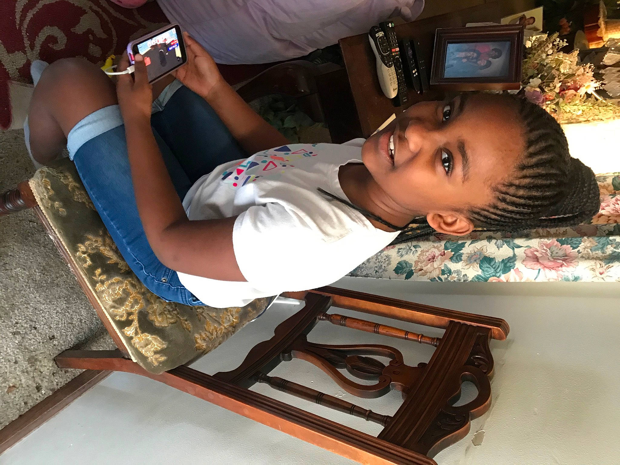 Zamari is registered to the contest to win money with this photo: audio_equipment, chair, child, comfort, cool, elbow, electronic_device, eyewear, flooring, fun, hairstyle, human_leg, joy, knee, person, room, sitting, sportswear, t_shirt, thigh